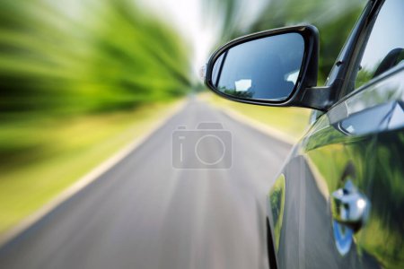 Téléchargez les photos : Voiture sur la route de campagne avec arrière-plan flou mouvement. - en image libre de droit