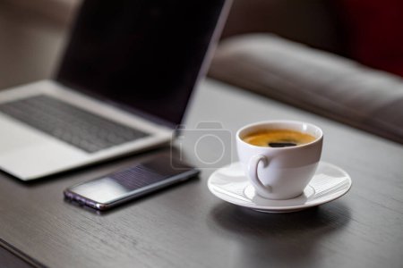 Foto de Taza de café con portátil en la mesa de madera en la cafetería - Imagen libre de derechos