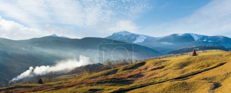 Photo for Misty early daybreak in autumn Carpathian mountain, Ukraine (Jasynja Village and Svydovets Range in far). Three shots stitch image. - Royalty Free Image