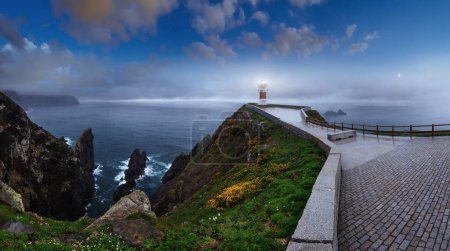 Téléchargez les photos : Glow Cape Ortegal Lighthouse (Province de A Coruna, Galice, Espagne). Nuit d'été après la pluie vue. - en image libre de droit