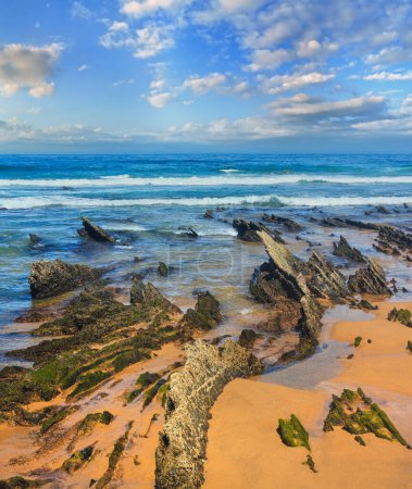 Photo for Rock formations on sandy beach (Algarve, Costa Vicentina, Portugal). Stormy weather. Three shots stitch image. - Royalty Free Image