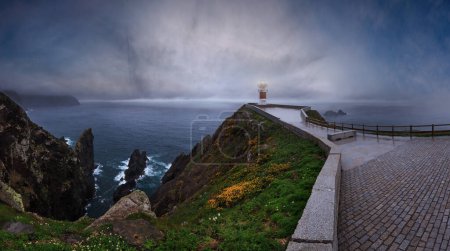 Téléchargez les photos : Glow Cape Ortegal Lighthouse (Province de A Coruna, Galice, Espagne). Vue d'été pluvieux tard dans la soirée. - en image libre de droit