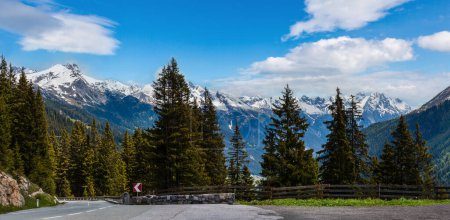 Téléchargez les photos : Alpes d'été paysage montagneux avec route, forêt de sapins sur pente et sommets rocheux enneigés à l'extrême, Autriche
. - en image libre de droit