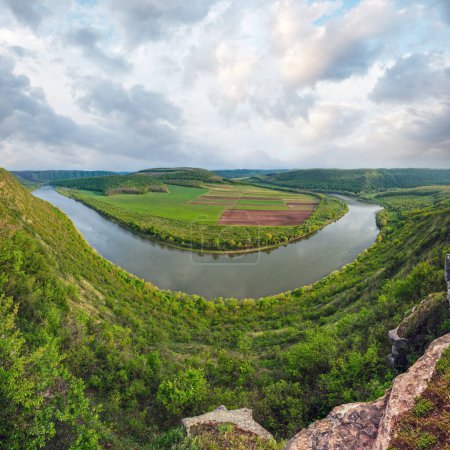 Foto de Vista superior de la tarde del cañón de curva del río Dnister, con campos de primavera en la costa. Región de Ternopil, Ucrania, Europa
. - Imagen libre de derechos