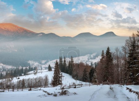 Photo for Sunrise morning winter mountain village outskirts in Black Cheremosh river valley between alp. View from rural snow covered path on hill slope with christianity crosses, Zelene, Verkhovyna, Ukraine. - Royalty Free Image