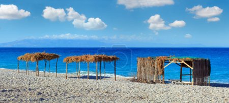 Téléchargez les photos : Summer morning beach with sunbeds, canopies and white pebble (Borsh, Albania). - en image libre de droit
