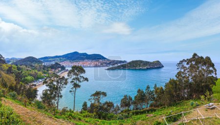 Photo for Summer Lekeitio town coastline and San Nicolas island (isla de San Nicolas), Biscay, Spain. All people are unrecognized. - Royalty Free Image