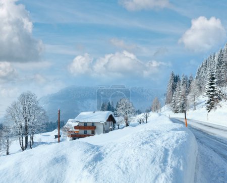 Téléchargez les photos : Matin hiver vue rurale brumeuse avec route alpine et maison sur le bord de la route
. - en image libre de droit
