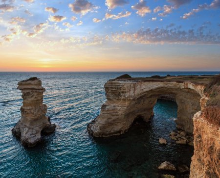 Foto de Crepúsculo paisaje marino con acantilados, arco rocoso y pilas (faraglioni), en Torre Sant Andrea, costa del mar de Salento, Puglia, Italia - Imagen libre de derechos