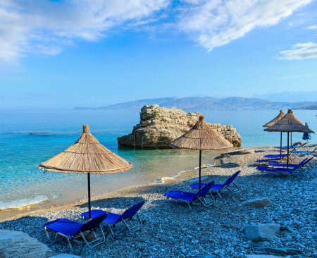 Foto de Mañana de verano Playa Pulebardha con tumbonas, sombrillas y guijarros (Saranda, Albania
). - Imagen libre de derechos