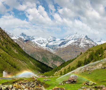 Photo for Rainbows in irrigation water spouts in Summer Alps mountain (Switzerland, near Zermatt) - Royalty Free Image