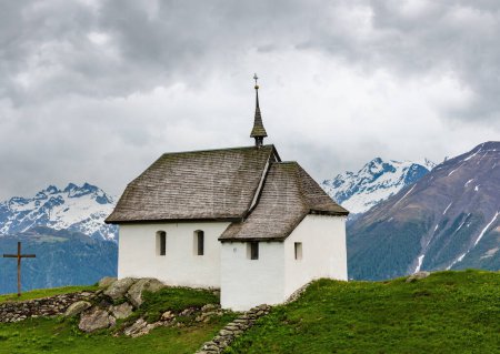 Téléchargez les photos : Jolie petite église ancienne dans le village de montagne des Alpes Bettmeralp, Suisse. Vue nuageuse d'été
. - en image libre de droit