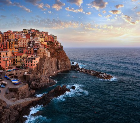 Photo for Beautiful summer Manarola - one of five famous villages of Cinque Terre National Park in Liguria, Italy, suspended between Ligurian sea and land on sheer cliffs. People unrecognizable. - Royalty Free Image