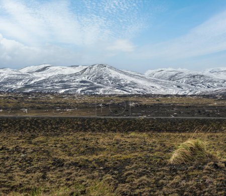 Foto de Coloridas montañas Landmannalaugar bajo cubierta de nieve en otoño, Islandia. Campos de lava de arena volcánica en primer plano. - Imagen libre de derechos