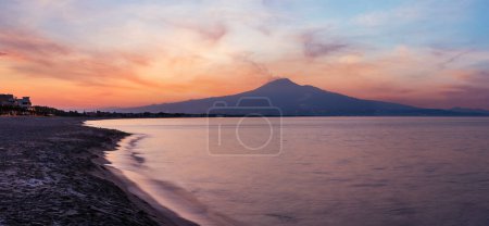 Photo for Beautiful sunset twilight on Agnone Bagni sea beach with smoky Etna volcano in far (Siracusa, Sicily, Italy). - Royalty Free Image