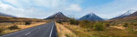 Téléchargez les photos : Route et vue sur la montagne pendant le voyage en auto en Islande. Paysage islandais spectaculaire avec une nature pittoresque : fjords, champs, nuages, glaciers, cascades. - en image libre de droit