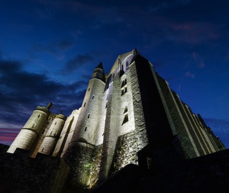 Téléchargez les photos : Mont Saint-Michel vue de nuit. Construit au XI-XVI siècles. La façade principale de l'église construite au 12ème siècle. Architecte William de Volpiano
. - en image libre de droit