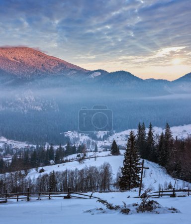 Photo for Sunrise morning winter mountain village outskirts in Black Cheremosh river valley between alp. View from rural snow covered path on hill slope with christianity crosses, Zelene, Verkhovyna, Ukraine. - Royalty Free Image