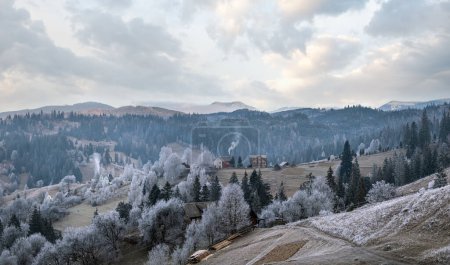 Photo for Winter coming. Picturesque foggy and moody morning scene in late autumn mountain countryside with hoarfrost on grasses, trees, slopes. Ukraine, Carpathian Mountains. - Royalty Free Image