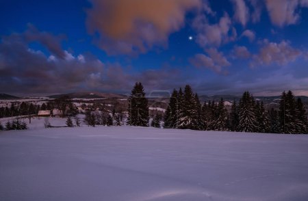 Photo for Night alpine village outskirts. Winter snowy hills and fir trees. - Royalty Free Image