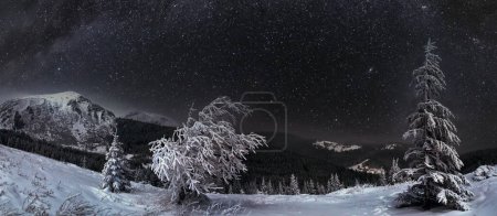 Foto de Noche invierno montaña paisaje en luna llena luz de la luna y casa con ventanas iluminadas - Imagen libre de derechos