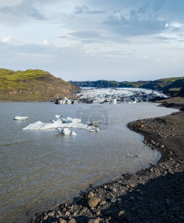 Téléchargez les photos : Slheimajkull glacier pittoresque dans le sud de l'Islande. La langue de ce glacier glisse du volcan Katla. Beau lagon lacustre glaciaire avec blocs de glace et montagnes environnantes. - en image libre de droit