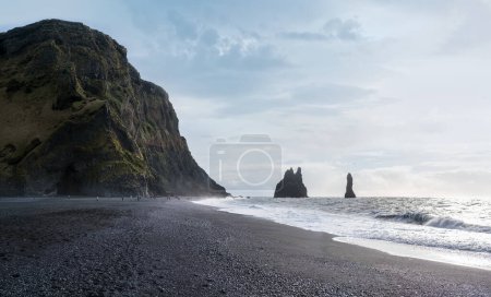 Der berühmte Black Sand Ocean Beach, der Berg Reynisfjall und malerische Basaltsäulen, Vik, Südisland. Menschen unkenntlich gemacht.