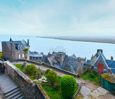 Téléchargez les photos : Matin vue nuageuse sur la mer depuis les murs du Mont Saint-Michel
. - en image libre de droit