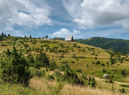 Foto de Pintoresco paisaje montañoso de verano del Parque Nacional de Durmitor, Montenegro, Europa, Balcanes Alpes Dináricos, Patrimonio de la Humanidad por la UNESCO. Pequeña cabaña de madera en la cima de la colina
. - Imagen libre de derechos