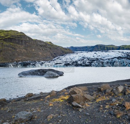 Foto de Soheimajokull pintoresco glaciar en el sur de Islandia. La lengua de este glaciar se desliza desde el volcán Katla. Hermosa laguna glacial con bloques de hielo y montañas circundantes. - Imagen libre de derechos