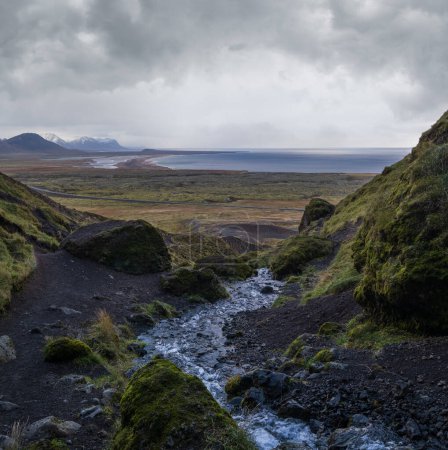 Téléchargez les photos : Vue pendant le voyage en auto dans les hautes terres de l'ouest de l'Islande, la péninsule de Snaefellsnes, le parc national Snaefellsjokull. Vue spectaculaire sur la toundra volcanique depuis la gorge de Raudfeldsgja le long du ruisseau jusqu'à la côte océanique. - en image libre de droit
