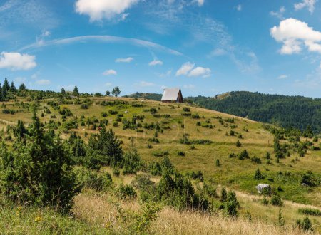 Foto de Pintoresco paisaje montañoso de verano del Parque Nacional de Durmitor, Montenegro, Europa, Balcanes Alpes Dináricos, Patrimonio de la Humanidad por la UNESCO. Pequeña cabaña de madera en la cima de la colina
. - Imagen libre de derechos