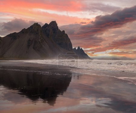Sunrise Stokksnes cape sea beach y Vestrahorn Mountain con su reflejo en la superficie húmeda de arena volcánica negra, Islandia. Increíble paisaje natural, destino de viaje popular.
