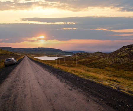 Téléchargez les photos : Vue pendant le voyage en auto dans les hautes terres de l'ouest de l'Islande, la péninsule de Snaefellsnes, le parc national Snaefellsjokull. Paysage de toundra volcanique, montagnes, cratères, lacs, routes de gravier. Modèle de voiture méconnaissable. - en image libre de droit
