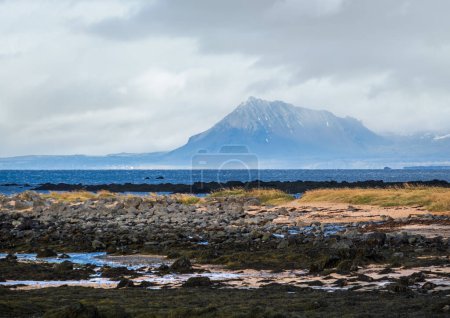 Foto de Vista durante el viaje en auto en las tierras altas de Islandia Occidental, península de Snaefellsnes, Parque Nacional Snaefellsjokull. Espectacular paisaje de tundra volcánica con montañas, cráteres, costa rocosa del océano. - Imagen libre de derechos