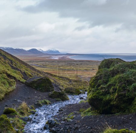 Photo for View during auto trip in West Iceland highlands, Snaefellsnes peninsula, Snaefellsjokull National Park. Spectacular volcanic tundra view from Raudfeldsgja Gorge along stream to ocean coast. - Royalty Free Image