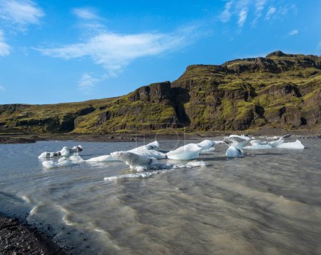 Slheimajkull malerischer Gletscher im Süden Islands. Die Zunge dieses Gletschers rutscht vom Vulkan Katla ab. Schöne Gletschersee-Lagune mit Eisblöcken und umliegenden Bergen.