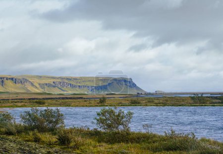 Téléchargez les photos : Vue depuis la route nationale pendant le voyage en auto en Islande. Paysage islandais spectaculaire avec une nature pittoresque : hameaux, montagnes, côte océanique, fjords, champs, nuages, glaciers, cascades. - en image libre de droit
