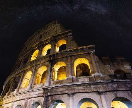 Foto de El Coliseo arruina la vista nocturna con el cielo estrellado de la Vía Láctea. El símbolo de la Roma Imperial, Italia. - Imagen libre de derechos