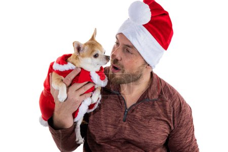 Foto de Hombre y cachorro con sombrero de Navidad y vestido aislado sobre un fondo blanco - Imagen libre de derechos