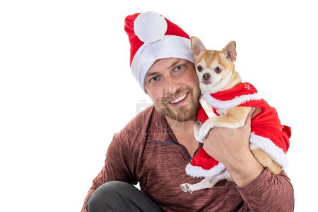 Téléchargez les photos : Homme et chiot avec chapeau et robe de Noël isolés sur un fond blanc - en image libre de droit