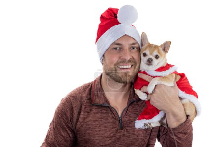 Foto de Hombre y cachorro con sombrero de Navidad y vestido aislado sobre un fondo blanco - Imagen libre de derechos