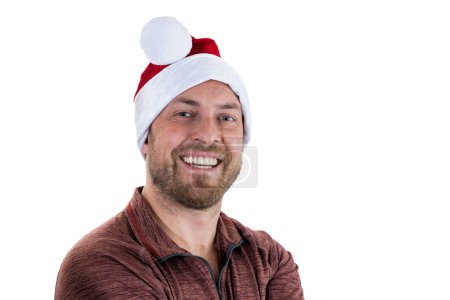 Téléchargez les photos : Portrait d'un jeune homme aux cheveux faciaux portant un chapeau de Père Noël sur fond blanc - en image libre de droit