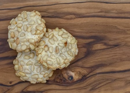 Foto de Primer plano de unas galletas de pignoli italianas recién horneadas sobre una mesa de madera - Imagen libre de derechos