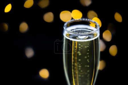 Photo for Close up of a champagne flat on a dark background with blurred lights in the back - Royalty Free Image