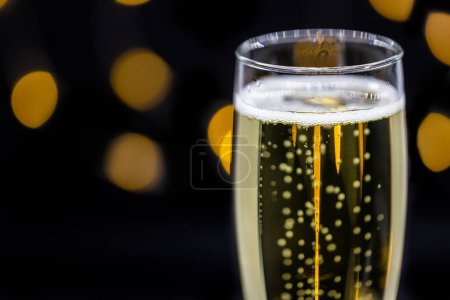 Téléchargez les photos : Close up of a champagne flat on a dark background with blurred lights in the back - en image libre de droit