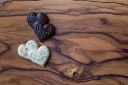 Photo for Close up of heart shaped chocolates on a wooden cutting board - Royalty Free Image