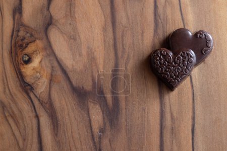 Photo for Close up of heart shaped chocolates on a wooden cutting board - Royalty Free Image