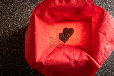 Foto de Heart shaped chocolates in a box with a light inside for a glow and a black lid for copy space - Imagen libre de derechos