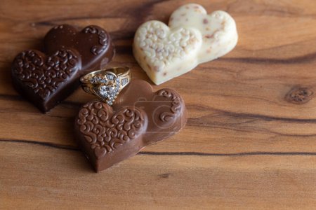 Photo for Heart shaped ring with chocolates on a wooden box - Royalty Free Image